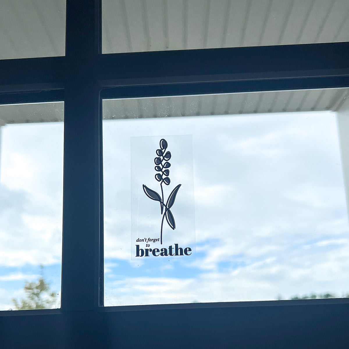 Clear window cling of lavender with words "don't forget to breathe" on window.